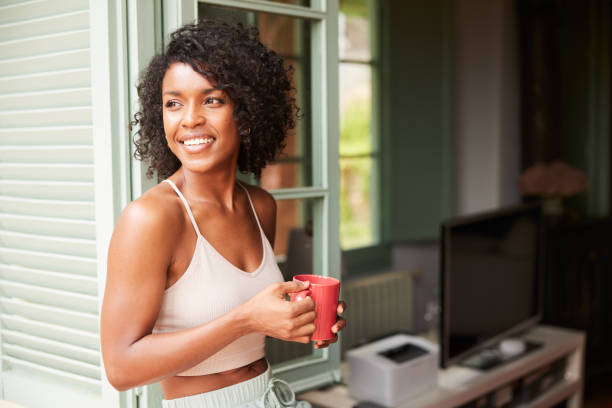 istock Enjoying watching her children play outside while this attractive multiracial woman has her morning coffee 1436629061