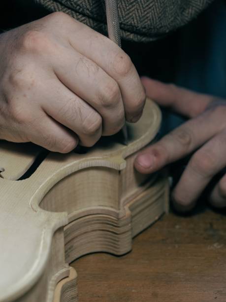 istock violin maker cutting out a channel on the front table of the instrument 1436631283