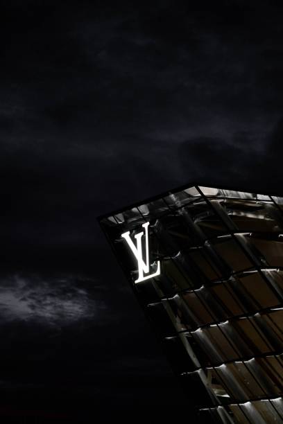 Vertical Shot Of A Louis Vuitton Banner On A Building At Night In