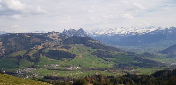 istock Beautiful scenery of green valley with mountains under cloudy sky 1436634419