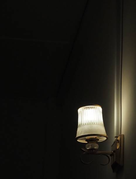 istock Closeup of a lamp on a wall in dark room 1436635220