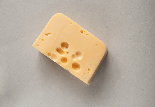 piece of cheese with holes on isolated background close up
