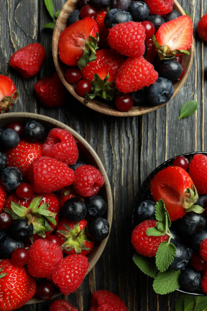 istock Bowls with berry mix on wooden background 1436641103