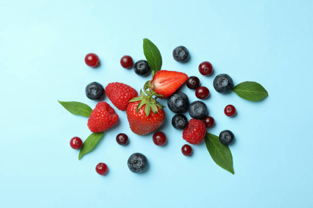 istock Delicious fresh berry mix on blue background 1436642069