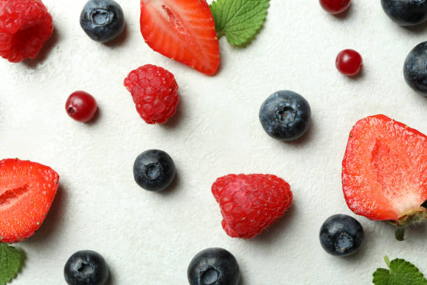 istock Delicious fresh berry mix on white textured background 1436642441