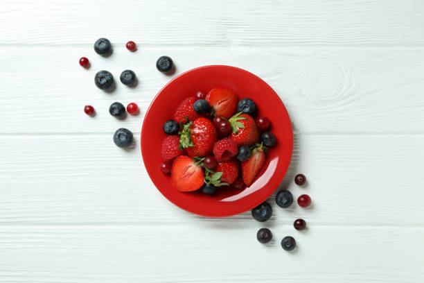 istock Plate with berry mix on white wooden background 1436642541