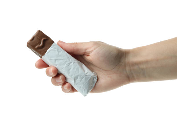 istock Female hand holds candy bar, isolated on white background 1436646188