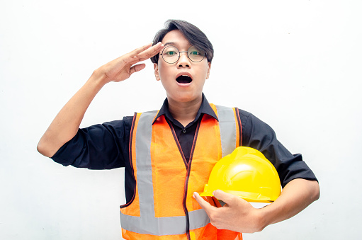 portrait of asian male worker using yellow helmey and orange vest smilling and shocked happily isolated over white