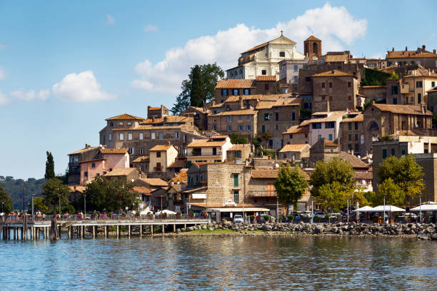 z brzegu jeziora bracciano wznosi się malownicza średniowieczna wioska anguillara sabazia z piękną architekturą - bracciano zdjęcia i obrazy z banku zdjęć