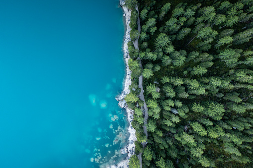 Stunning views of the lake Braies with glowing turquoise water, surrounded by alpine mountains of the Dolomites.