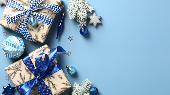 Festive Christmas banner template with gift boxes, fir branches, silver and blue decorations on pastel blue background. Christmas, winter holiday, New Year celebration concept.
