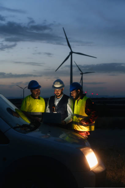 istock Electrical Engineer and technical specialists working on electricity wind power station project , planing green energy facility at night 1436657760
