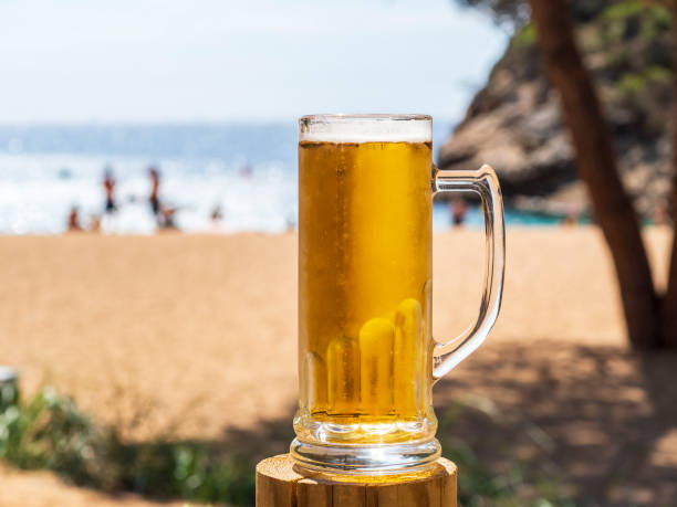 Pitcher of beer on the beach stock photo