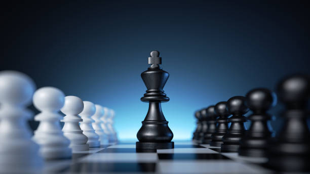 istock 3d rendering, chess game pieces over the blue background, black king is placed in the middle of the chessboard between two rows of black and white pawns. Politics concept, leadership metaphor 1436663429