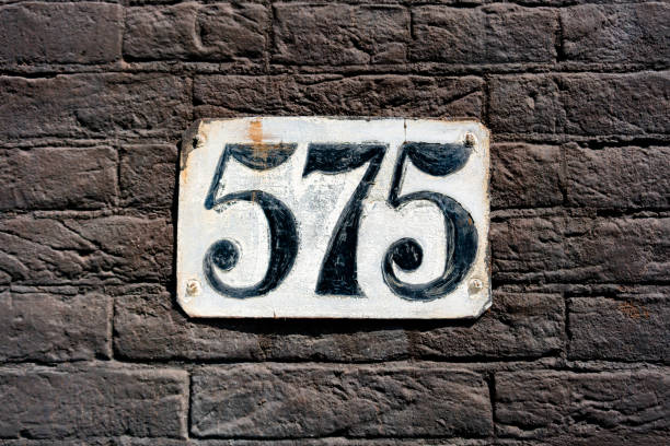 istock house number five hundred and seventy five. Hand painted on a white plate. 1436665909