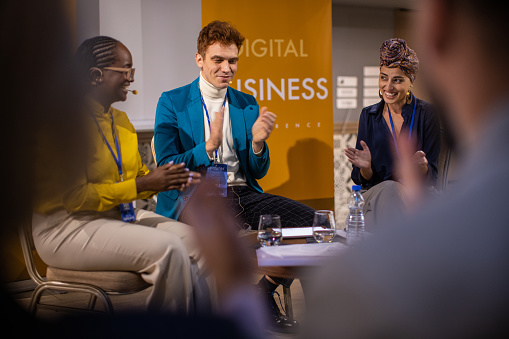 Business people attending panel discussion during business conference in convention center