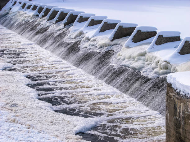 Water flowing from dam in winter frost