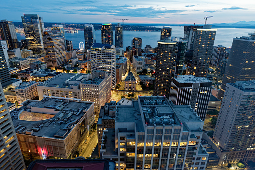Panoramic view across skyline of Seattle, the iconic spire of the Space Needle and the crowded skyscrapers of downtown brightly illuminated against the blue dusk sky, Washington, USA. ProPhoto RGB profile for maximum color fidelity and gamut.