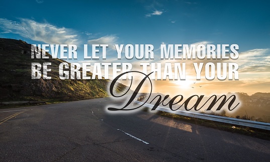 A scenic shot of a road surrounded by nature and a motivational quote about dreams \