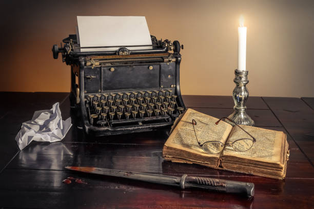 istock Vintage typewriter on a table next to a murdering knife and a book.A detective story concept. 1436675220