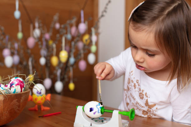 istock Cute toddler girl helping paint Easter eggs 1436676254
