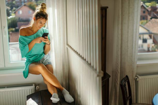 istock Young woman relaxing in bedroom and using mobile phone 1436676978