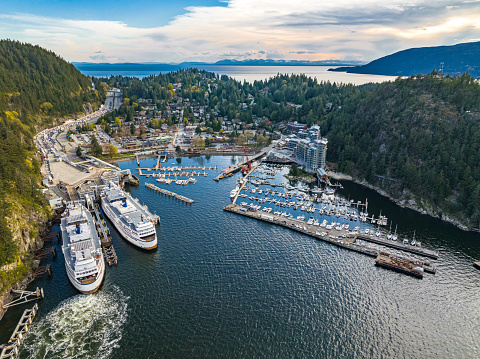 An aerial shot of the city, dense forest and moored boats and ferries at the harbor of Horseshoe Bay, West Vancouver, British Columbia, Canada