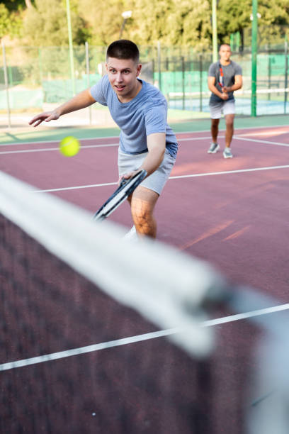istock Concentrated young man tennis player hitting ball with racket 1436677395