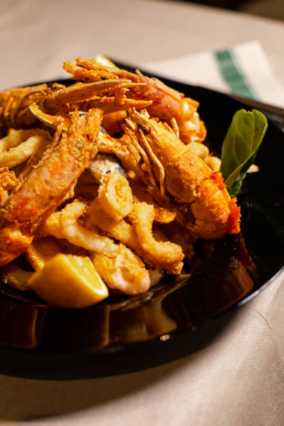 istock Fried prawns and squids served on a black plate 1436678660
