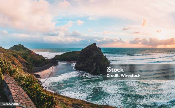 Scenic View Of The Rock Formation And Mountains Against Dusk Sky Piha Beach Auckland New Zealand Stock Photo - Download Image Now