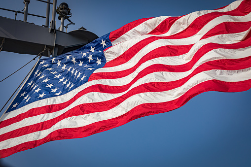 The American flag waving from US Navy ship at sea while underway