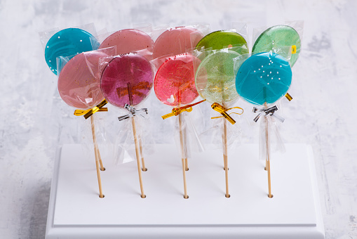 A number of colorful lollipops on a white surface