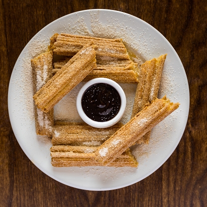 A top view of the Churros with sugar powder and chocolate sauce