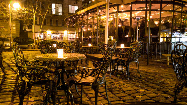 View of an empty street cafe with burning candles on the tables at night