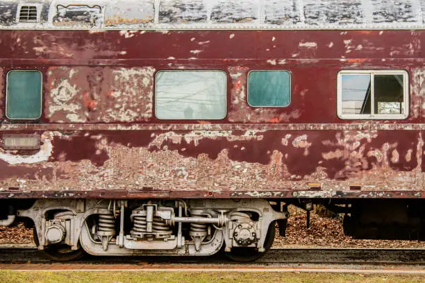 The old, weathered train railcar. Rusty train. Side view.
