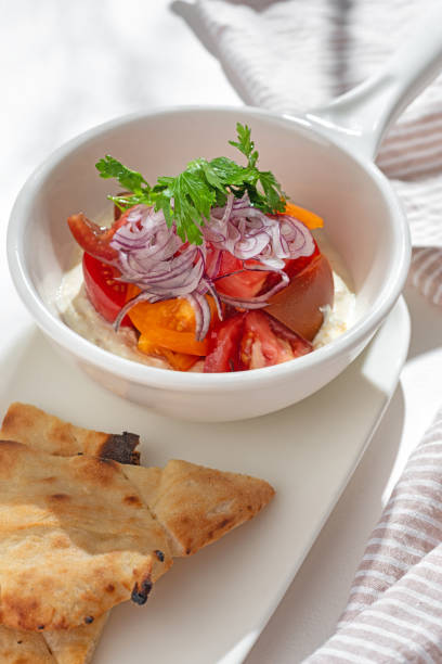 istock Appetizer. Vegetable salad: greek yogurt with cream cheese, tomatoes on light background 1436688299