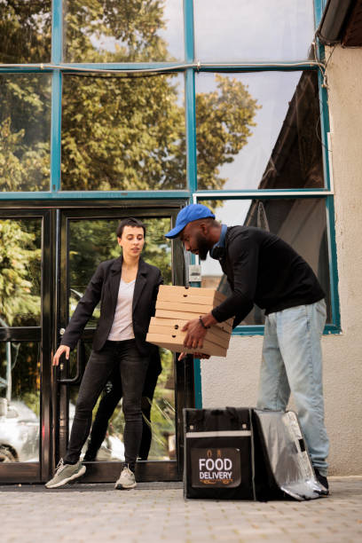 istock Customer receiving pizza boxes pile, courier taking out order 1436689739