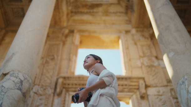young female tourist taking photos and videos in historical ancient town - turkey tourist ephesus roman imagens e fotografias de stock