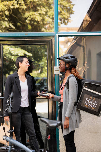 istock Smiling client paying for food delivery with credit card 1436691353