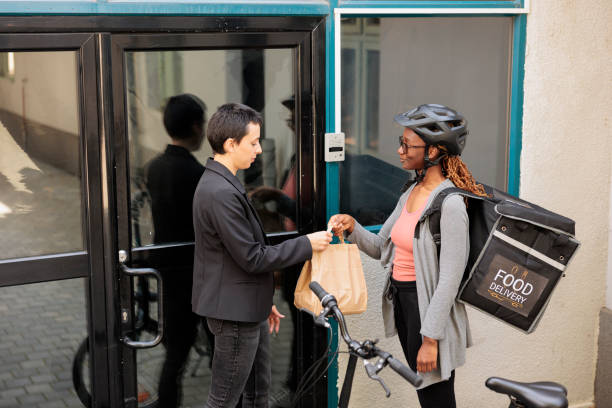 istock Office food delivery service, smiling courier giving client order 1436691500
