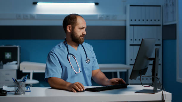 istock General practitioner nurse sitting at desk typing medical expertise on computer 1436693313