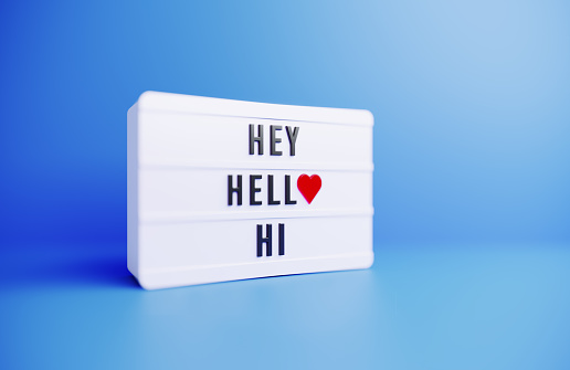 Hey Hello Hi written white lightbox sitting on blue background. Horizontal composition with copy space.