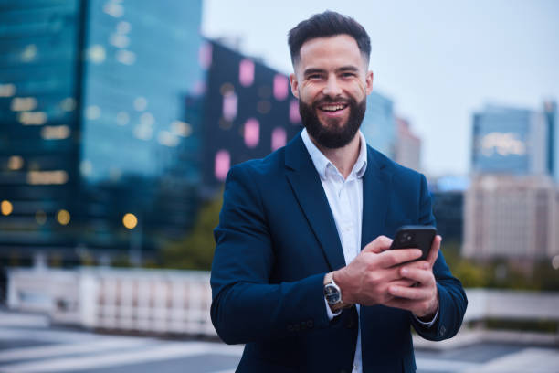 istock Businessman smiling while texting on his phone outside his office after work 1436694334