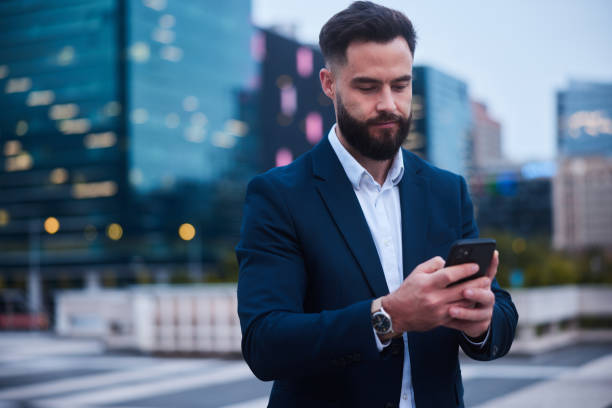 istock Businessman sending a text on his phone outside his office after work 1436694932