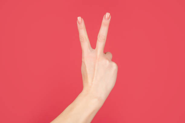 istock female hand showing peace gesture on red background 1436695336