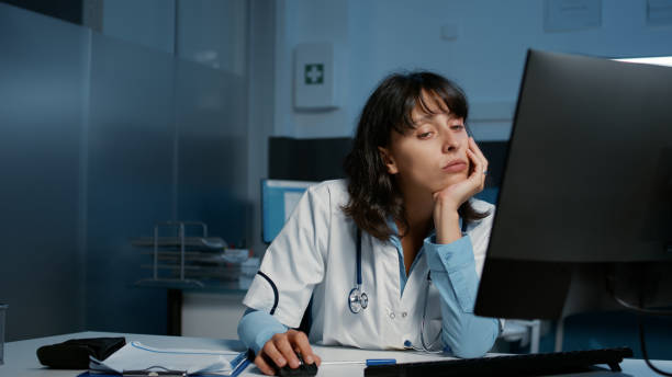 istock Exhausted stressed practitioner doctor working late at night in hospital office 1436696909