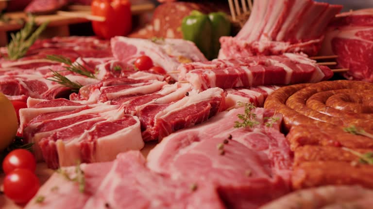 Close up delicious meat table layout raw steaks and sausages.