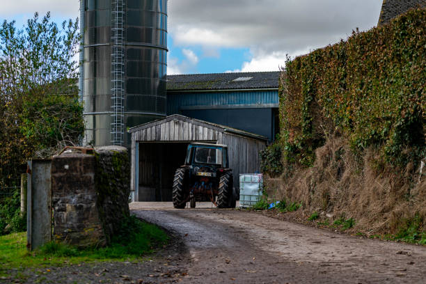 Three generation family of farmers work on farming equipment and do chores together while using technology