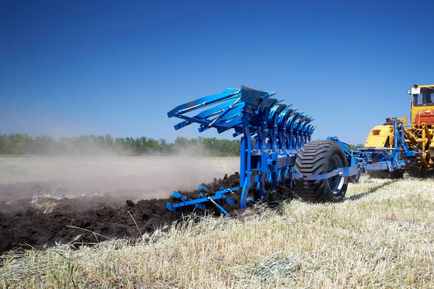 istock Tractor plows the land with a plow in the field. 1436700562