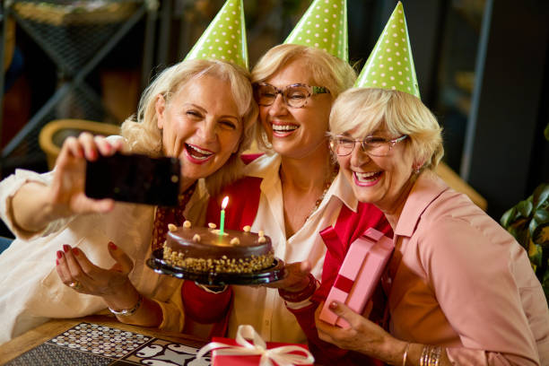 istock Senior ladies taking selfie while celebrating birthday in cafe 1436700763